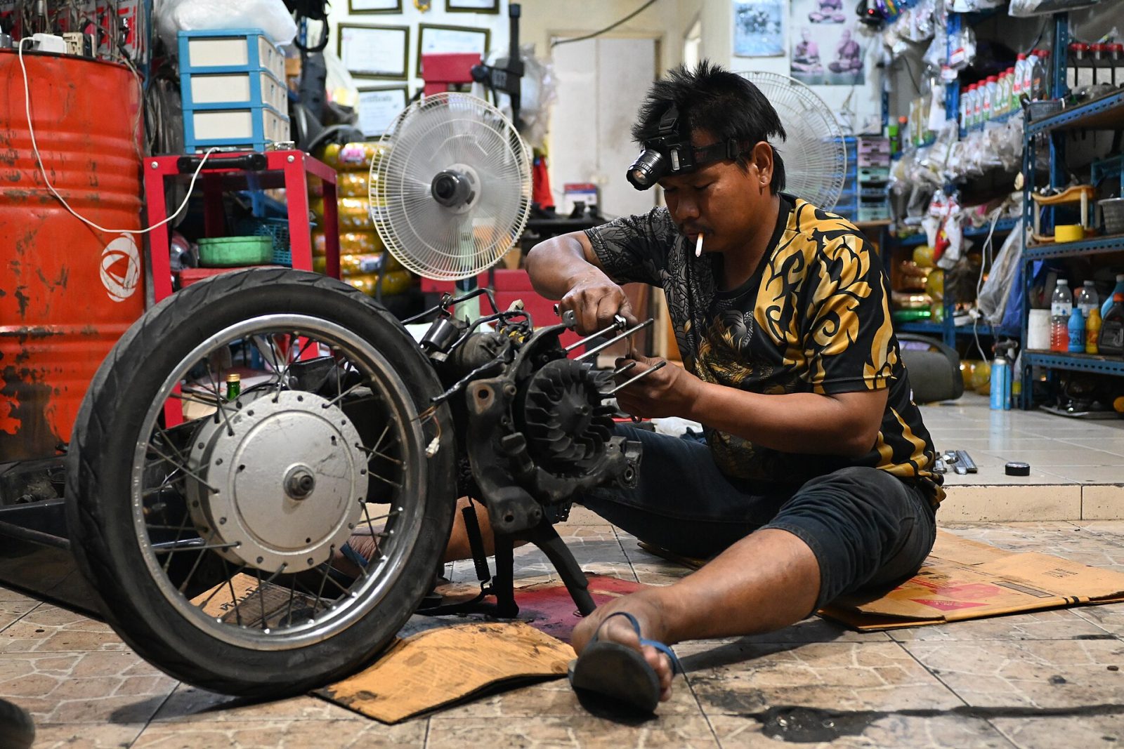 Meccanico che ripara il motore di una moto in officina